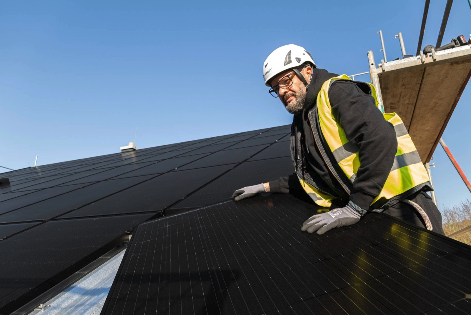 Monteur von AK-ON Haustechnik montiert eine Solaranlage auf einem Dach