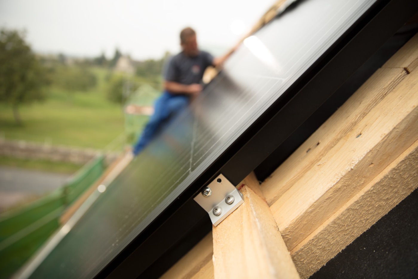 Monteur montiert Solarmodule auf einem Hausdach